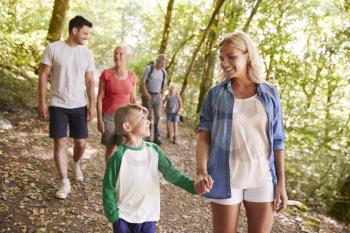 Multi Generation Family Enjoying Walk Along Woodland Path Together