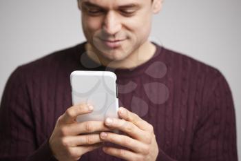 Close up of smiling young white man using a smartphone