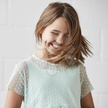 Happy Young Girl Posing In Studio Against White Wall
