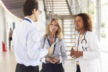 Three young male and female doctors in consultation