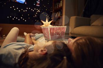 Father And Daughter Enjoying Movie Night At Home Together