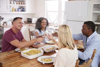 Mature Couple Entertaining Friends At Dinner Party