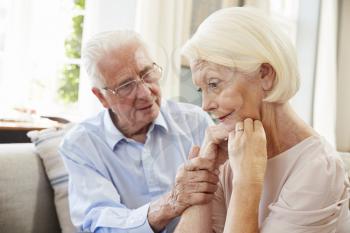 Senior Man Comforting Woman With Depression At Home