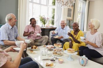 Group Of Senior Friends Enjoying Afternoon Tea At Home Together
