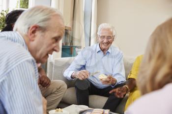 Group Of Senior Friends Enjoying Afternoon Tea At Home Together