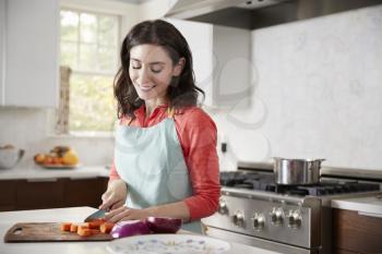 Woman chopping carrots in kitchen for Jewish passover meal