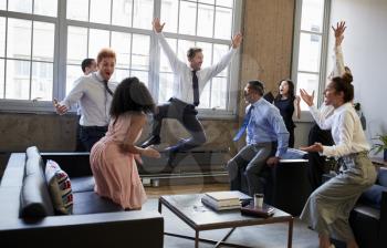 Business team jump for joy at hitting target in meeting