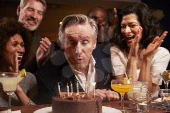 Group Of Middle Aged Friends Celebrating Birthday In Bar