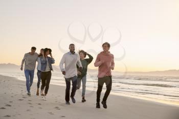 Group Of Friends On Walking Along Winter Beach Together