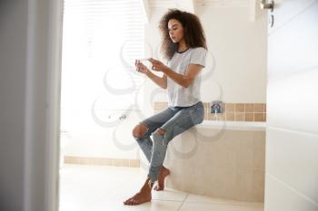 Concerned Woman In Bathroom With Home Pregnancy Test