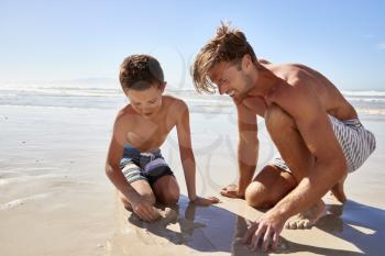 Father And Son On Summer Vacation Playing On Beach Together
