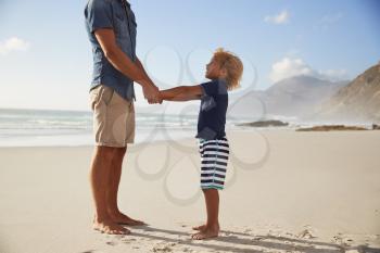 Father Holding Hands With Son On Summer Beach Vacation