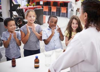 Classmates applauding teacher after a science experiment