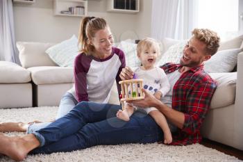 Young white family playing together in sitting room