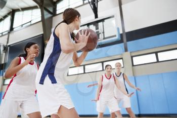 Female High School Basketball Team Passing Ball On Court