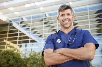 Happy male healthcare worker smiling to camera outdoors