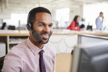 Black male call centre worker looking at screen, close-up