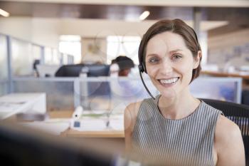 Young white woman working in a call centre smiling to camera