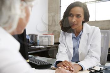 Young female doctor in consultation with senior patient