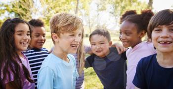 Multi-ethnic group of schoolchildren laughing, outdoors