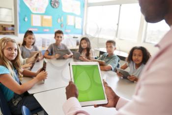 Teacher and kids using tablets in elementary school lesson