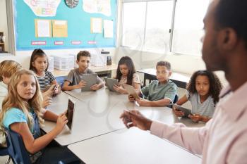 School kids learn to use tablets in elementary school lesson