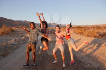 Young adult friends have fun striking poses in the desert