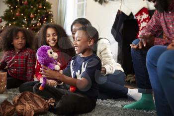 Son Opening Gift As Multi Generation Family Celebrate Christmas At Home Together