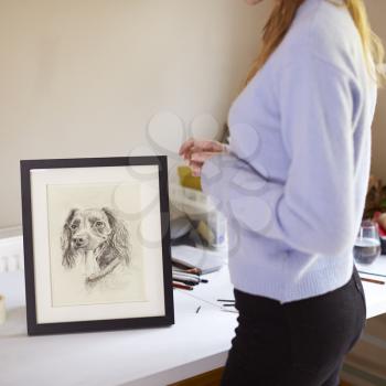 Close Up Of Female Teenage Artist Framing Charcoal Drawing Of Dog In Studio