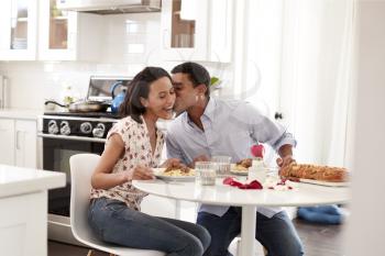 Young couple having romantic meal sitting at table in the kitchen, selective focus