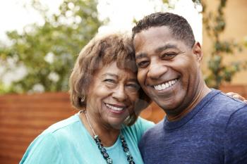 Senior black woman and her middle aged son smiling to camera, head and shoulders, close up