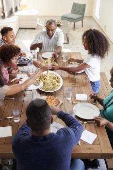 Three generation black family sitting at dinner table eating together, elevated view, vertical