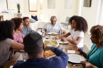 Three generation black family sitting at dinner table eating together, elevated view