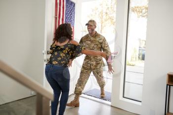 Millennial black male soldier returning home into the arms open of his wife, close up