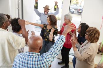 Millennial black couple arriving at a family party with gifts and champagne, elevated view
