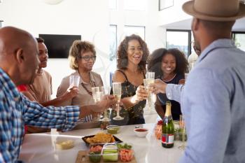 Three generation black family celebrating together make a toast with champagne,close up