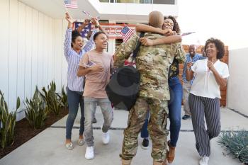 Excited three generation black family welcoming millennial soldier returning home,back view
