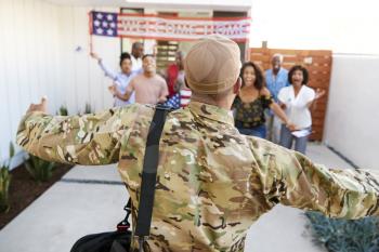 Three generation black family welcoming millennial soldier returning home,back view, focus on foreground