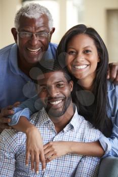 Portrait Of Smiling Senior Father With Adult Son And Daughter Hugging At Home