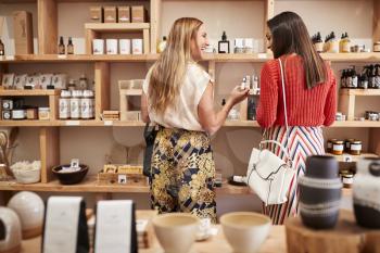 Two Female Friends Shopping In Independent Cosmetics Store Together