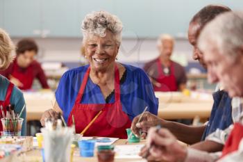 Portrait Of Retired Senior Woman Attending Art Class In Community Centre