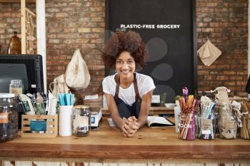 Portrait Of Female Owner Of Sustainable Plastic Free Grocery Store Behind Sales Desk