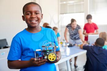 Portrait Of Male Student Building Robot Vehicle In After School Computer Coding Class
