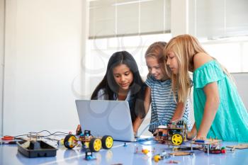Three Female Students Building And Programing Robot Vehicle In After School Computer Coding Class