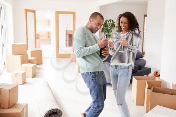 Couple Celebrating Moving Into New Home Opening Champagne