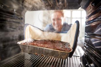 View Looking Out From Inside Oven As Woman Burns Dinner