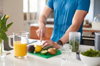 Close Up Of Man Preparing Ingredients For Healthy Juice Drink After Exercise