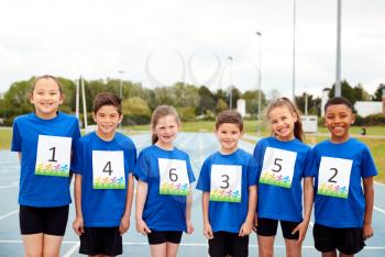 Portrait Of Children On Athletics Track Wearing Competitor Numbers On Sports Day