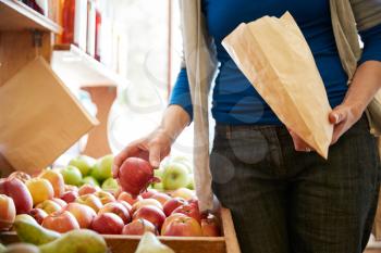 Close Up Of Woman Customer With Paper Bag Buying Fresh Apples In Organic Farm Shop