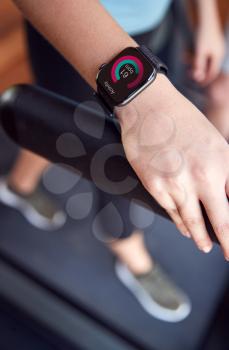 Close Up Of Woman Exercising On Treadmill Wearing Smart Watch